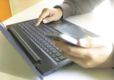 Hands using laptop and smartphone for online shopping with daytime soft lig.. Stock Photos