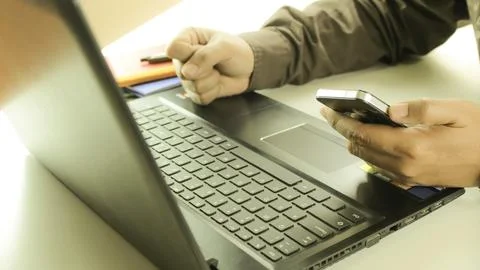 Hands using laptop and smartphone for online shopping with daytime soft lig.. 写真素材