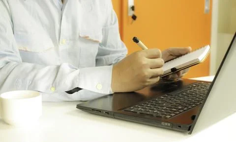 Hands using laptop and writing book for online shopping with daytime soft l.. Stock Photos
