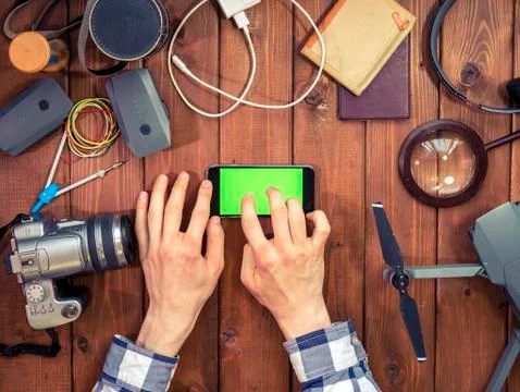 Hands using mobile phone with chroma key on the wooden table Stock Photos