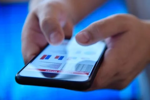 Hands using a mobile phone displaying financial charts Stock Photos