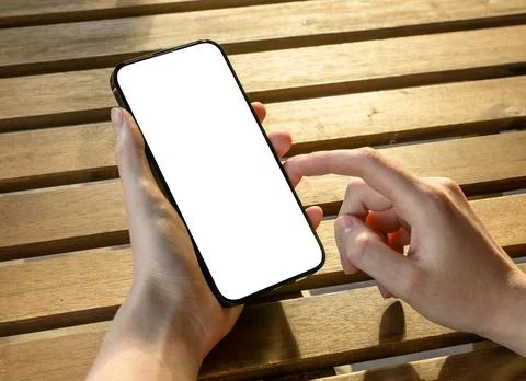 Hands using mobile phone mockup, screen mock up over wood table Stock Photos