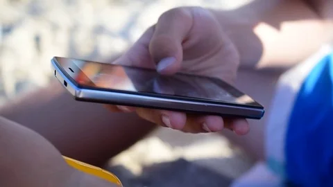 Hands using mobile smartphone on beach Video stock 69761359