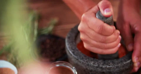 Hands using mortar and pestle to grind herbs and spices Stock Footage