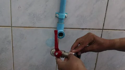 Hands using pipe wrapping tape to installing the faucet in the toilet room Video stock 146793780