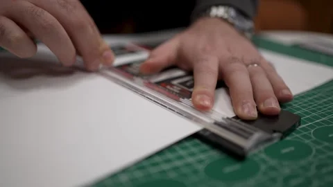 Hands using a rotary paper trimmer on a green self-healing cutting mat, wit.. Stock Footage 302869967