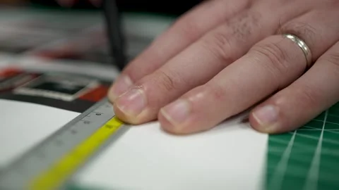 Hands using a ruler and technical pen to draw or measure on white paper, su.. Stock Footage 302869994