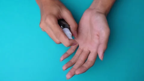 Hands using sanitizer spray isolated blue background Stock Footage 274624346