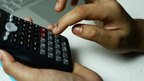 Hands Using Scientific Calculator with Laptop, Close-up of hands using a sc.. Видео 304961072