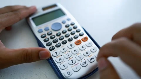 Hands Using Scientific Calculator on White Surface, Close-up of hands using.. Stock Footage 317736996