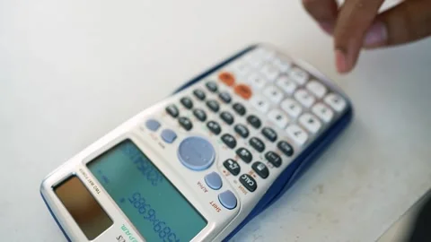Hands Using Scientific Calculator on White Surface, Close-up of hands using.. Stock Footage 317737000