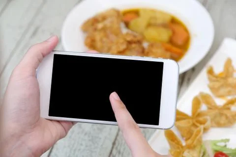 Hands using smart phone with blank screen over blur food background, mock up, Foto stock