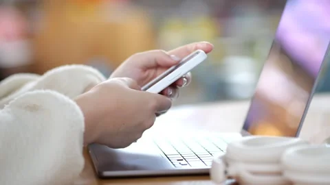 Hands using smartphone beside open laptop Stock Footage 346234810