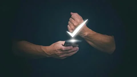 Hands using smartphone with glowing check mark icon Stock Photos