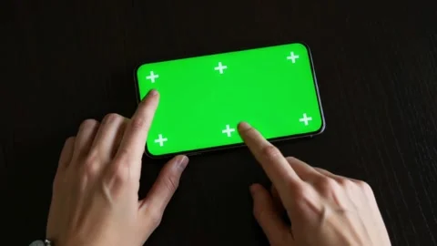 Hands Using Smartphone with Green Screen Display 4K Top view of two fingers.. Video stock 312076690