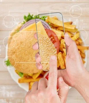 Hands using smartphone over burger and fries with digital interface Stock Photos