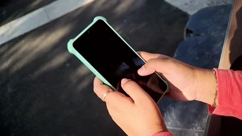 Hands Using Smartphone with Turquoise Case Outdoors in Sunlight Video Stock Footage 321116902