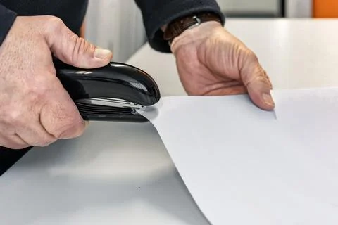 Hands using stapler to fasten paper documents in office Fotos Stock