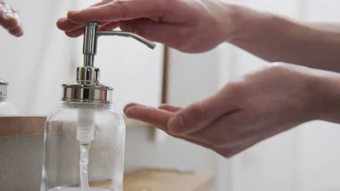 Hands using stylish Soap Dispenser made of glass using clear white liquid soap Stock Footage 145214272