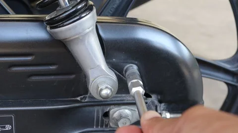 Hands using T - socket wrench remove the bolt, chain cover, motorcycle Stock Footage 145859504