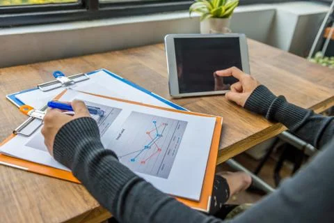 Hands using tablet and pointing at diagram business document Foto stock
