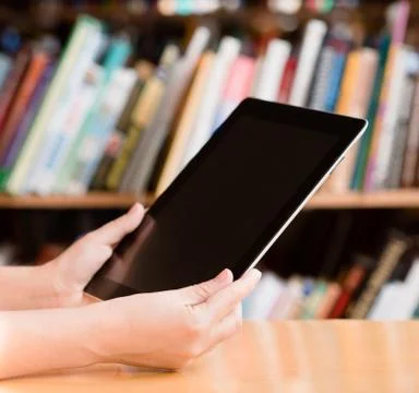 Hands using tablet computer in library Stock Photos