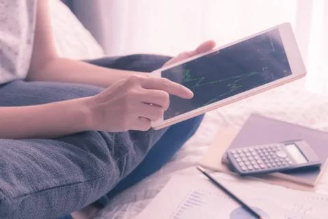 Hands using tablet, stock exchange graph, vintage style. Stock Photos