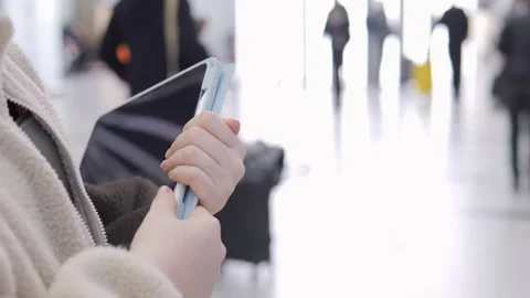 Hands using tablet with stylus in bustling airport corridor Stock Footage 341452434