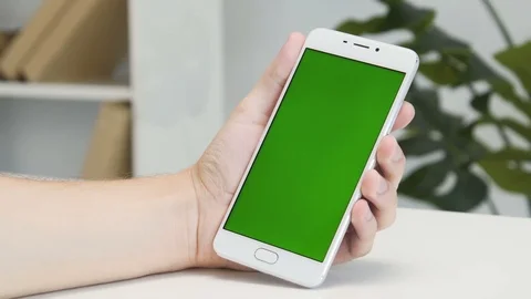 Hands using white smartphone with green screen at home. Stock Footage 93663296