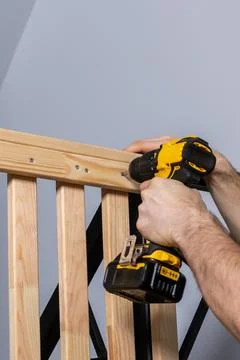 Hands Using Yellow and Black Cordless Drill on Wooden Structure Stock Photos