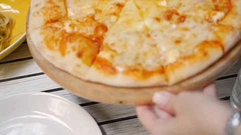 Hands of waiter puts ready tasty pizza on the table in the restaurant. Closeup Stock-Footage 114687557