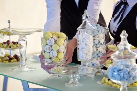 The hands of the waiters putting sweets on the table Foto stock