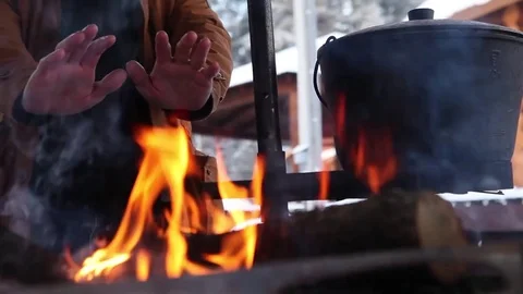 Hands warming themselves by the fire Stock Footage 73041589