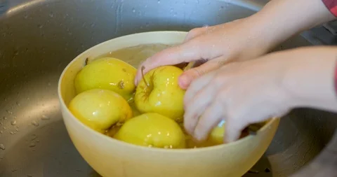 Hands washes yellow apples Stock Footage 129426612