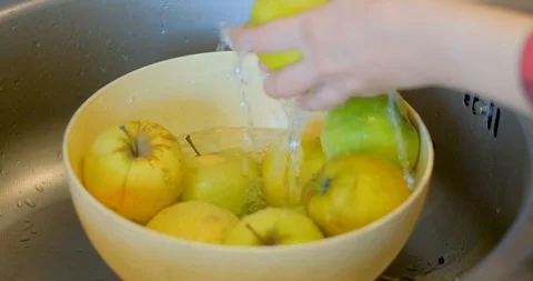 Hands washes yellow apples Stock Footage 129426858