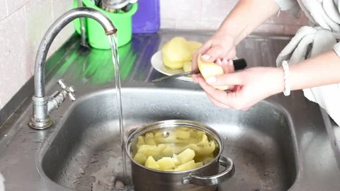 Hands washing and cutting potatoes in the sink  .Preparing vegetables for making Stock Footage 234307744