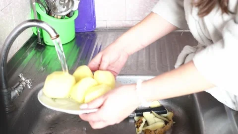 Hands washing and cutting potatoes in the sink  .Preparing vegetables for making Stock Footage 234307776