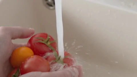 Hands washing tomatoes under running water in the white sink. Healthy eating Video stock 144966252
