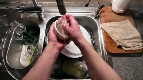 Hands Washing White Ceramic Cup With Pattern Under Running Water in Stainle.. Stock Footage 307849547