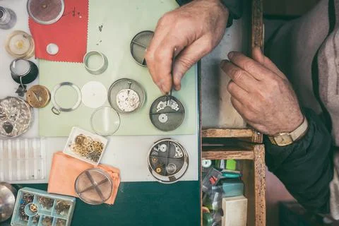 Hands of watchmaker fixing a watch in close-up Stock Photos