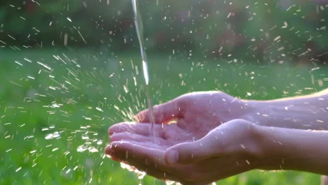 Hands with water splash, backlit by the evening sun, close up Stock Footage 110791670