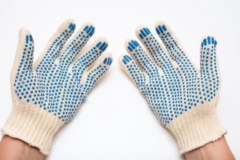 Hands wearing construction worker protective knitted dotted gloves on white Stock Photos
