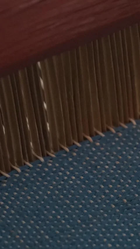 Hands weaving fabric on a traditional wooden loom with threads and natural Stock Footage 317737341