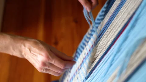 Hands Weaving with Weaving Needle on Loom with Blue and Beige Yarn Stock Footage 277175527