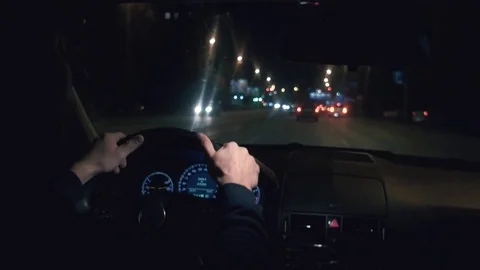 Hands on the wheel. The driver driving a black car at night. 库存影片 81179790