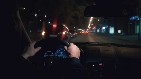 Hands on the wheel. The driver driving a black car at night. 库存影片 81179937