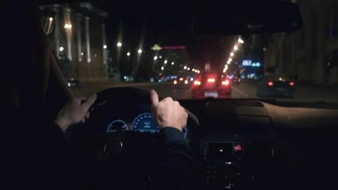 Hands on the wheel. The driver driving a black car at night. 库存影片 81180068
