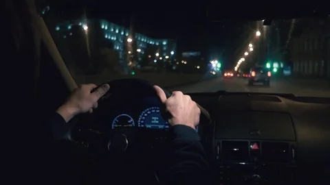 Hands on the wheel. The driver driving a black car at night. Stock-Footage 81180525