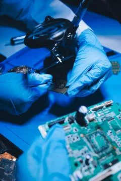 Hands in white gloves carefully repair a broken mobile device, meticulously.. Stock Photos