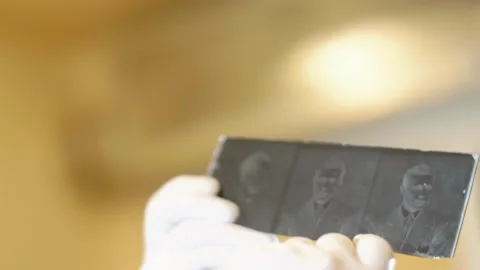 Hands in white gloves hold an old glass negative Stock Footage 243720750